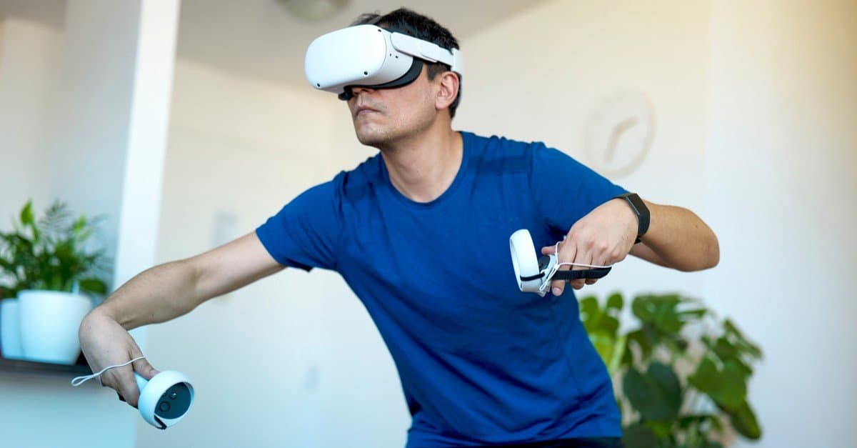 Young man playing a virtual reality game at home using an Oculus VR headset.