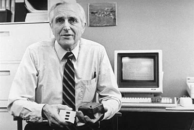 Douglas Engelbart in 1984, showing the first mouse and a new one.