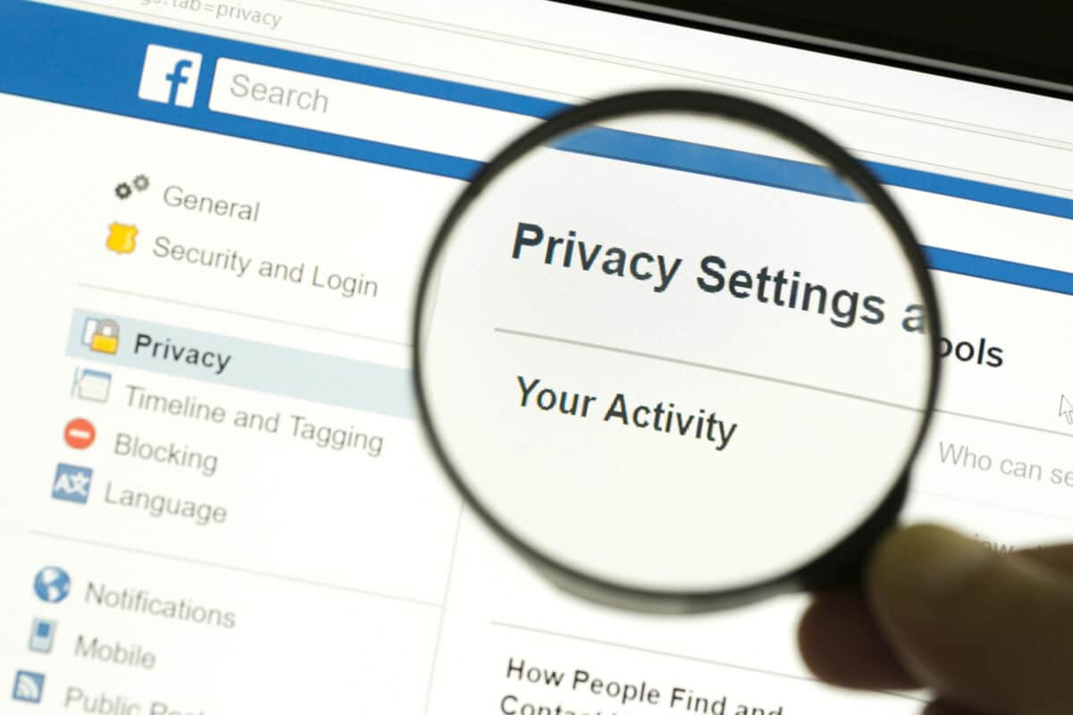 Facebook account privacy settings examined under a magnifying glass.