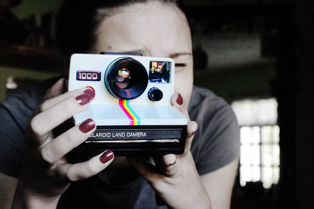Lady taking a photo with polaroid 1000 camera