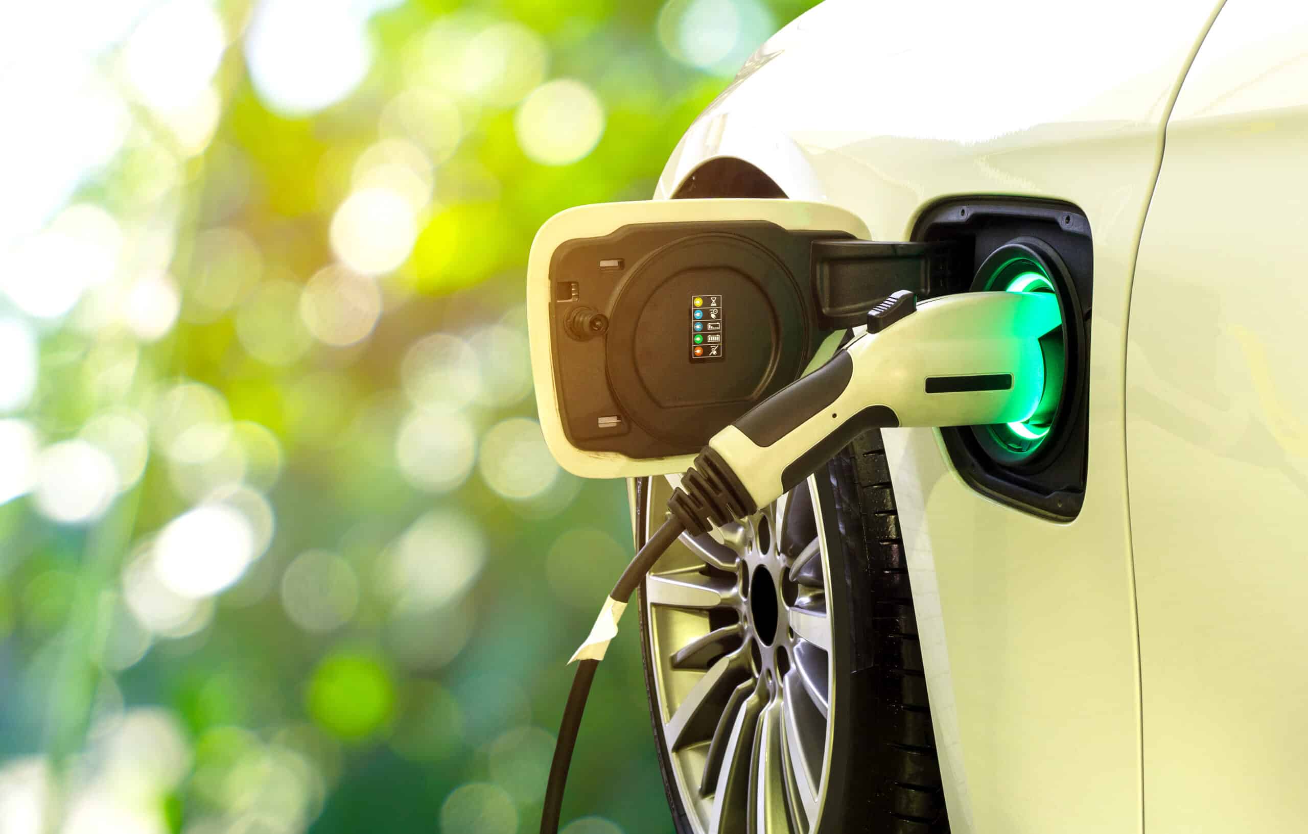 Electric car with the power cable supply plugged at a charging station