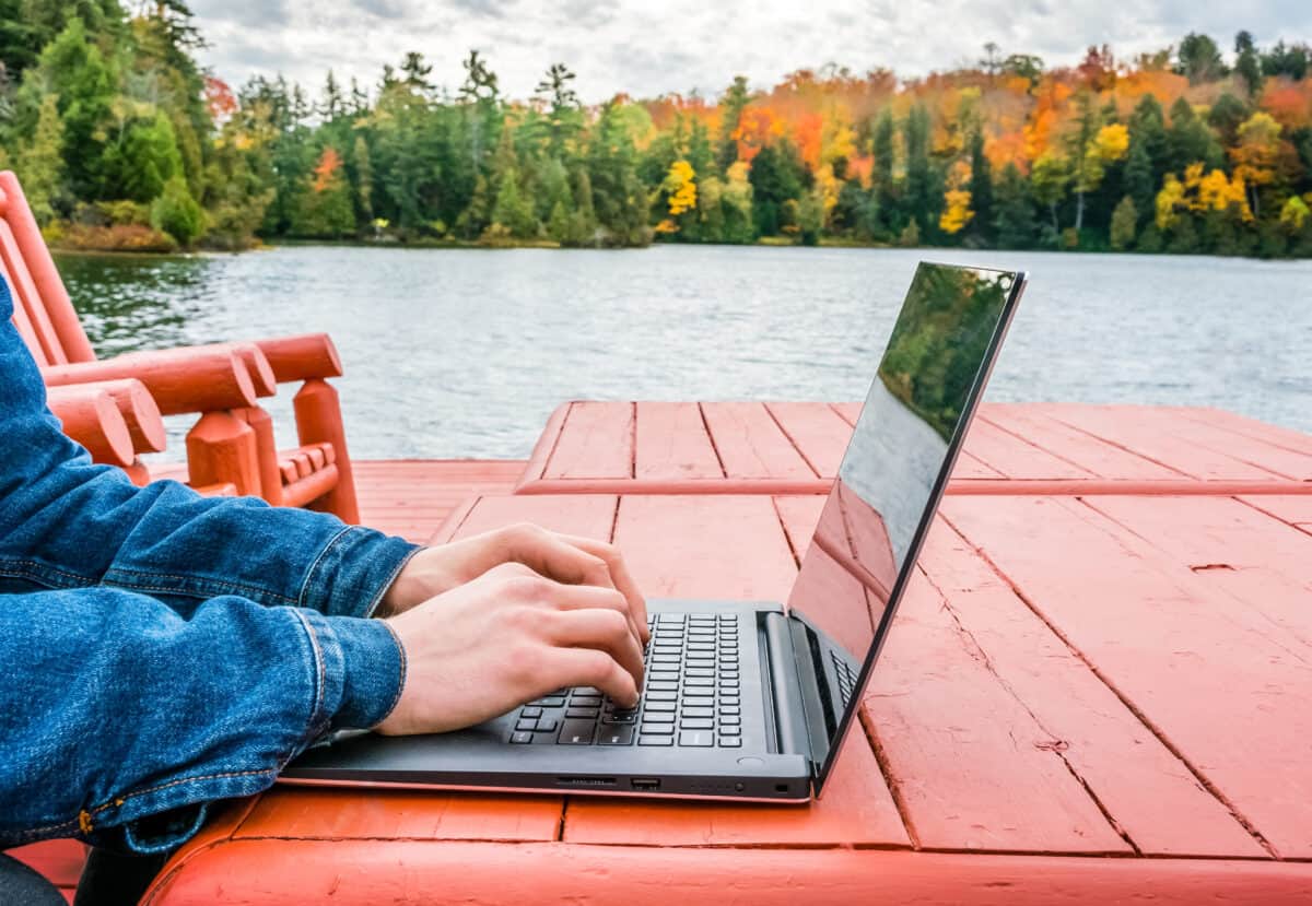 Man writing on laptop outside