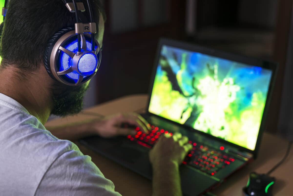 Gamer playing video games on PC laptop