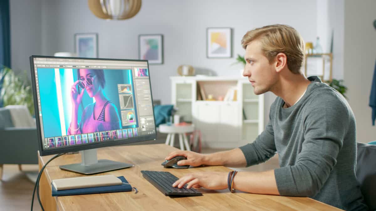 Man sitting at desk editing photo photoshop