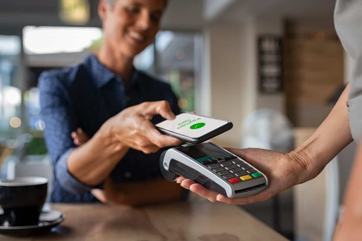 Woman paying bill retailer with NFC payment app