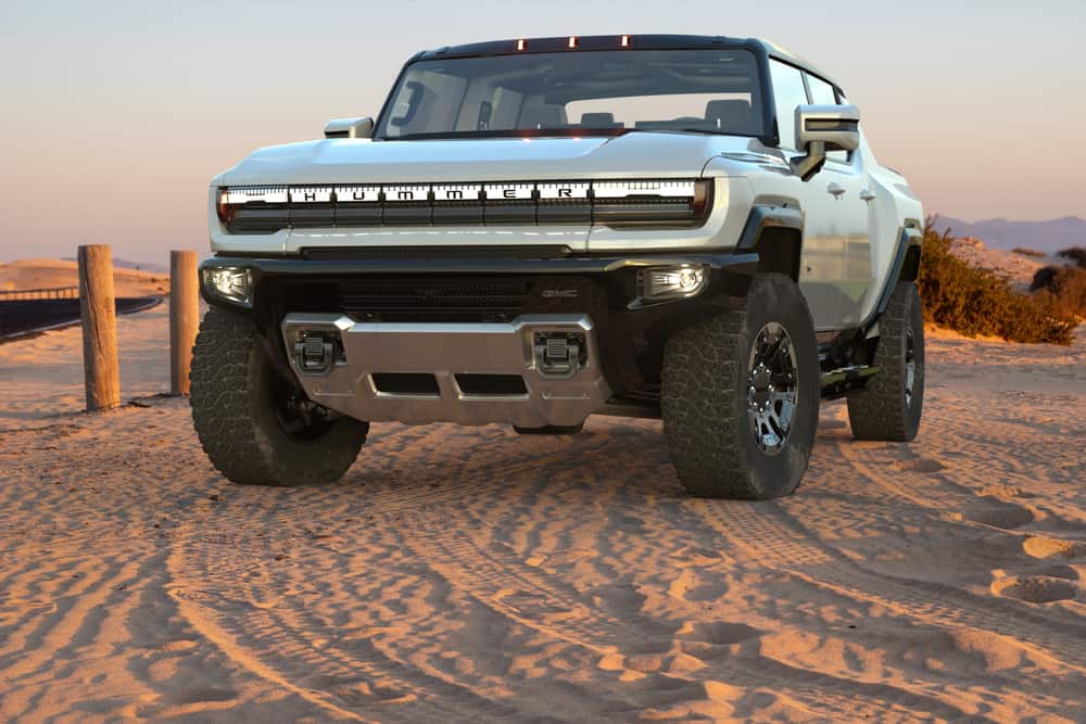 White GMC hummer EV offroading on sand