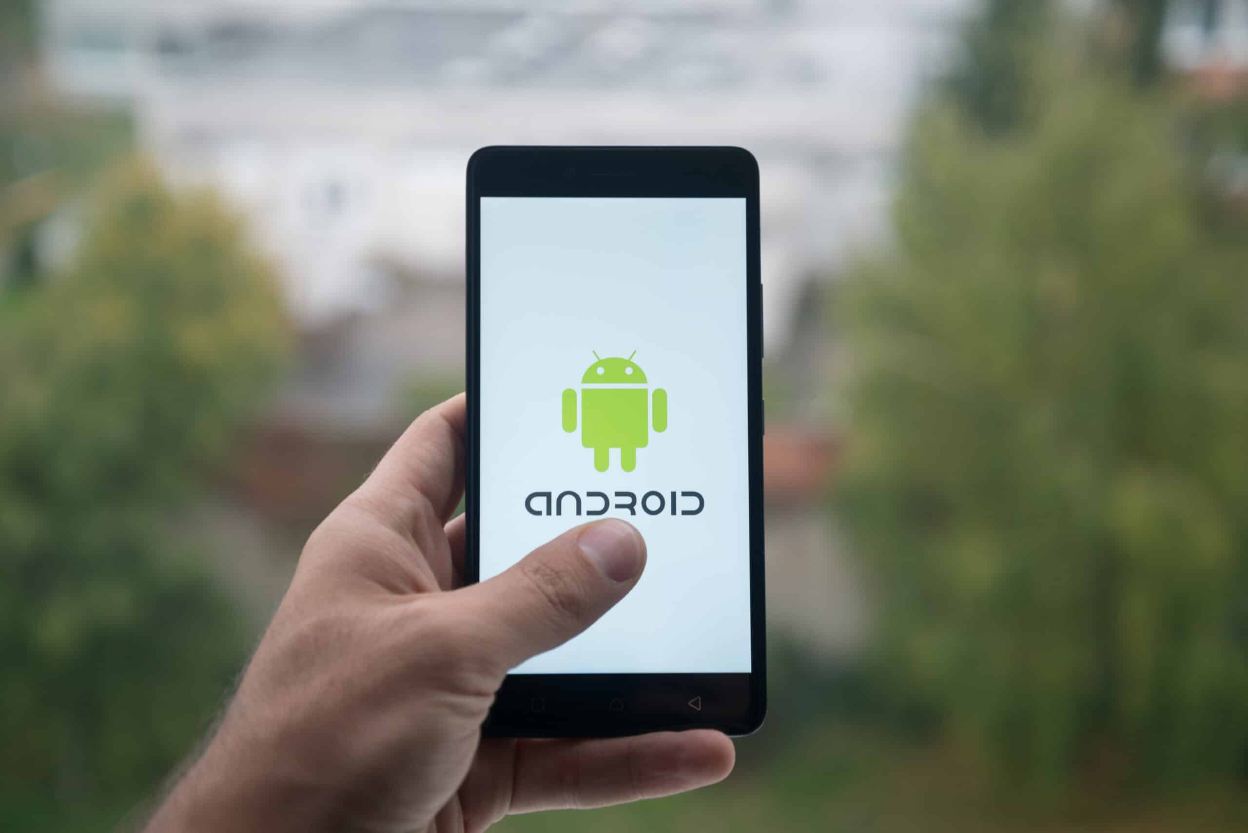 hand holding a smartphone with android logo