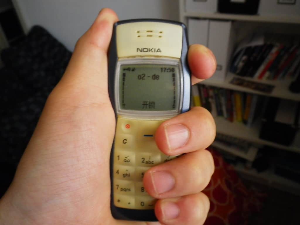 hand tightly holding a Nokia 1100