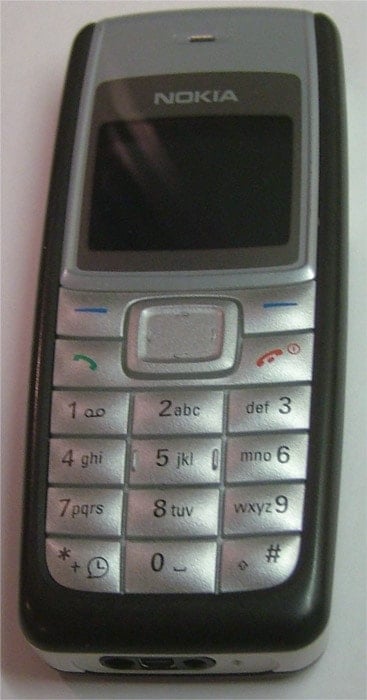 Three grey Nokia 1110 phones on a dark background