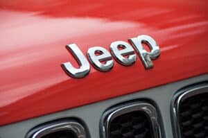 jeep logo in front of red car