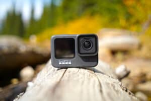 GoPro HERO 9 Black action camera sitting on log outdoors