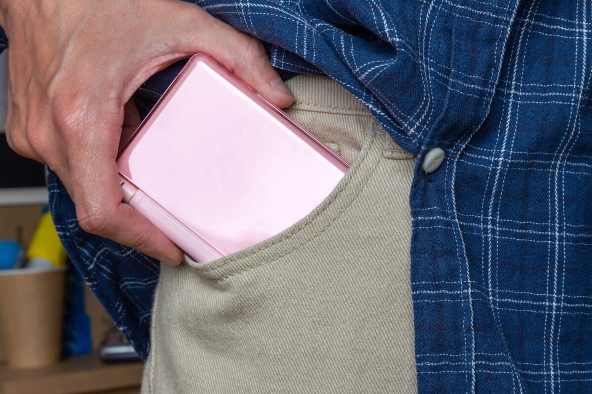 Man putting handheld console nintendo in his pocket