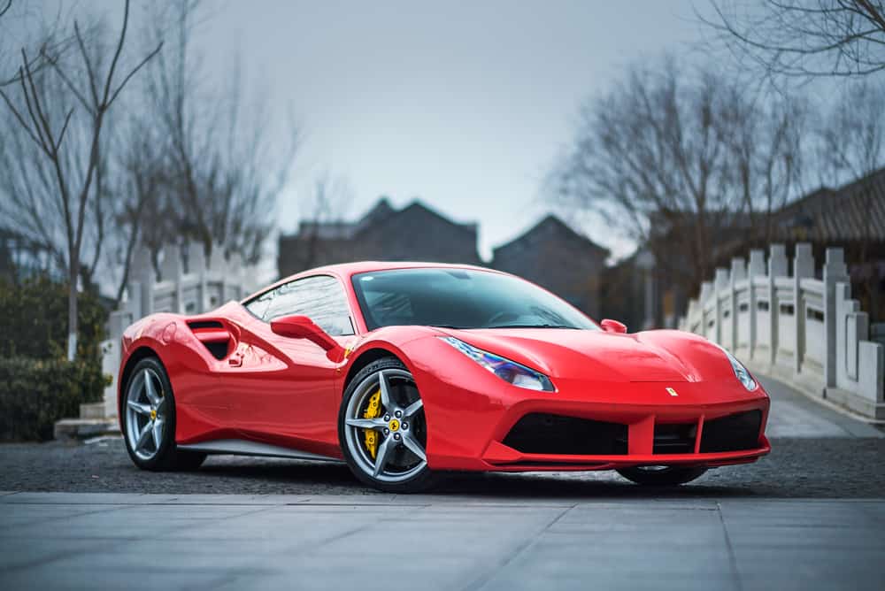 red Ferrari 488 GTB parked in front of a stone bridge