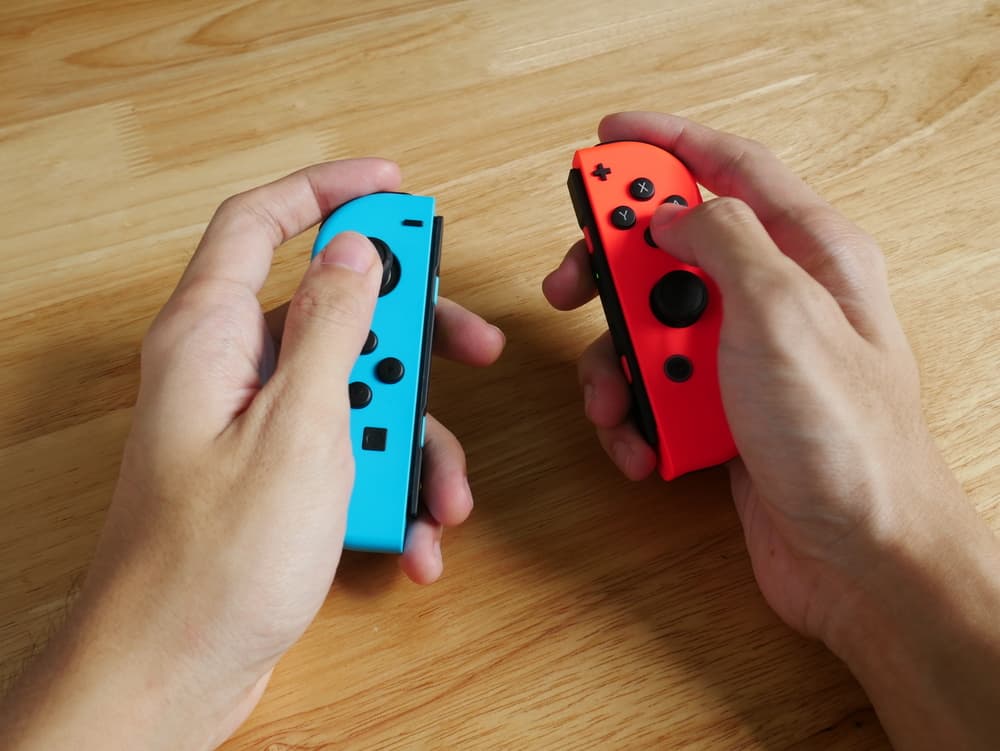 Hands holding Nintendo Switch controllers