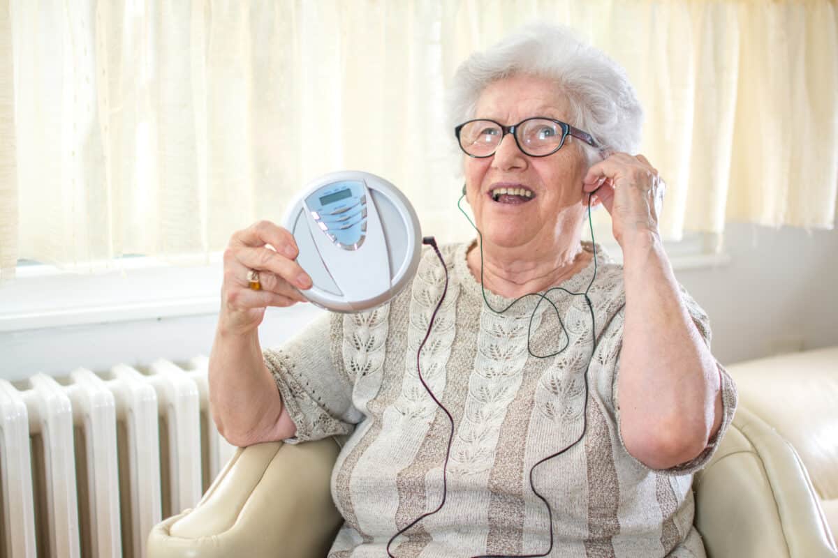 Elderly senior woman listening to music on CD player