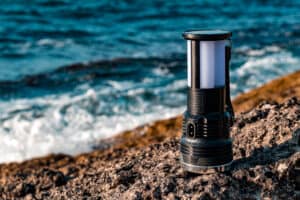 solar powered camp lamp on the rocks next to the sea