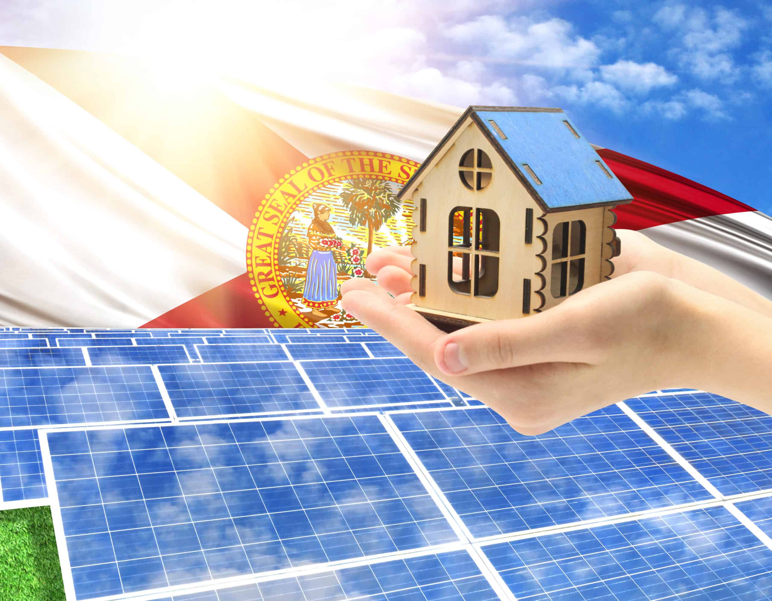 photo with solar panels and a hand holding a toy house with Florida state flag with sun rays