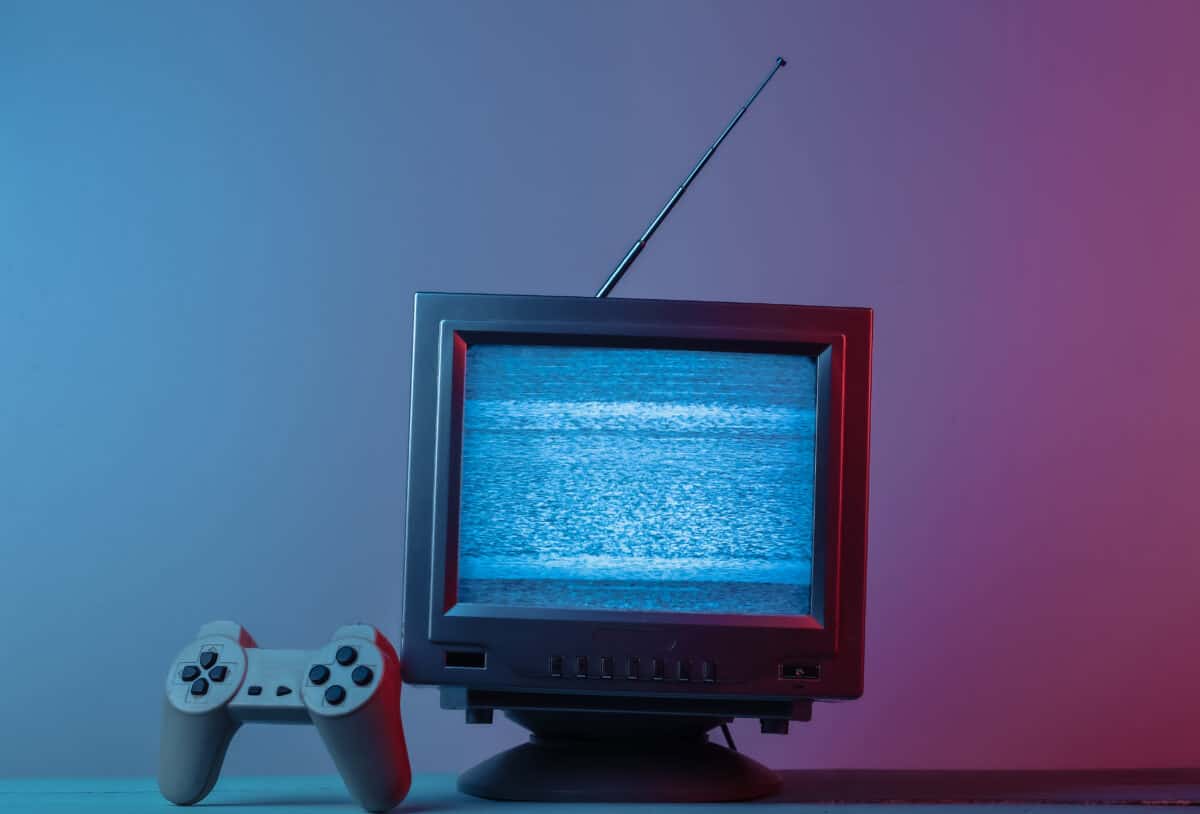 Old CRT television with video game controller resting alongside it.