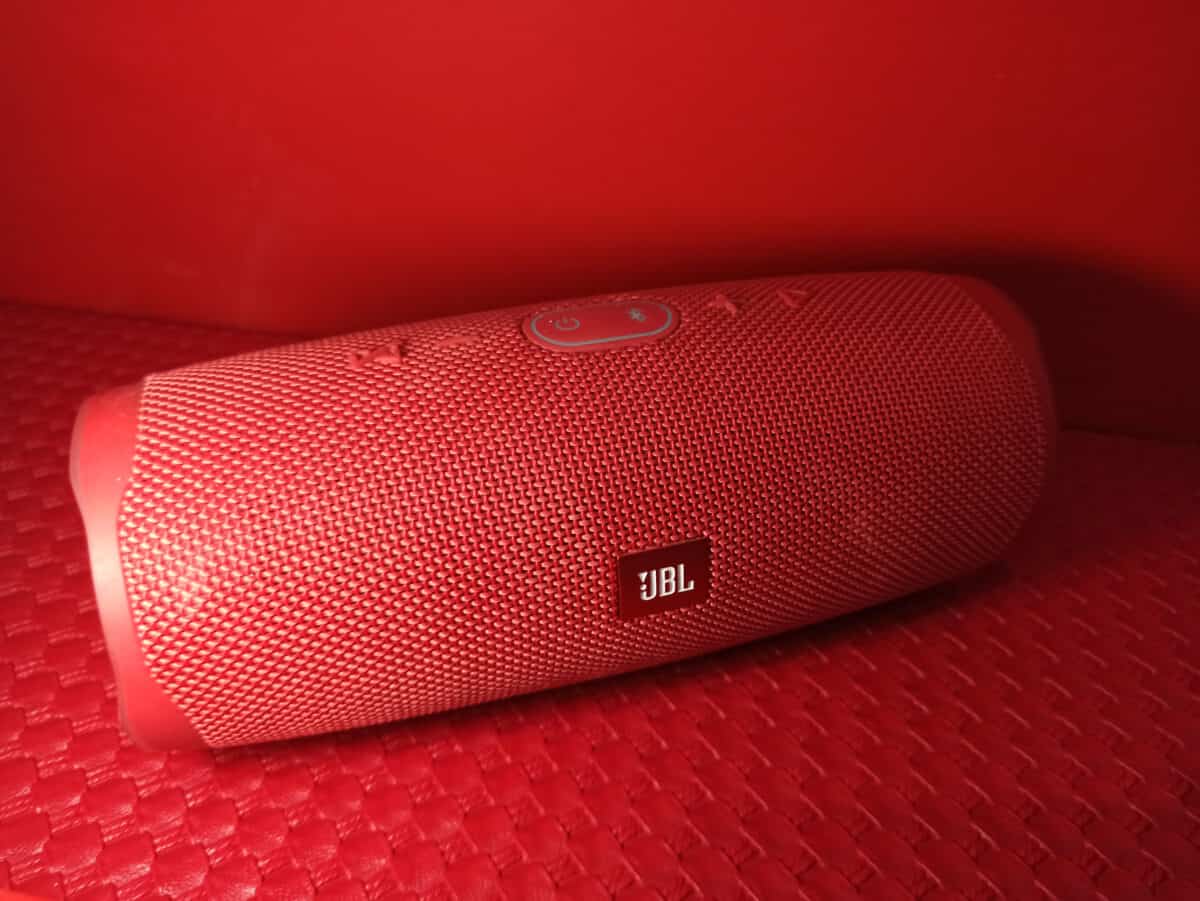 Red JBL Charge with red background.