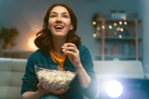 woman watching tv movie with popcorn