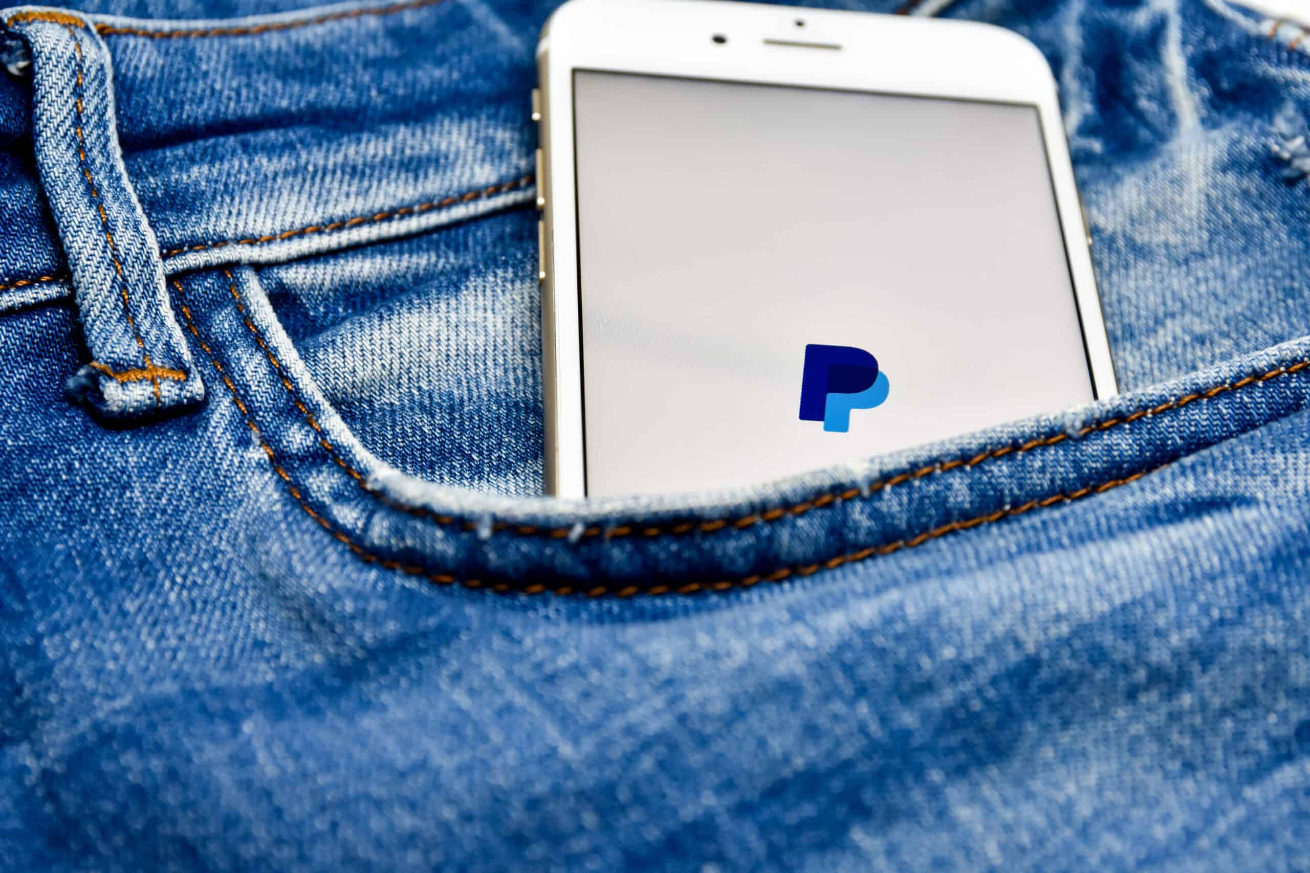 paypal app on mobile phone in jeans pocket