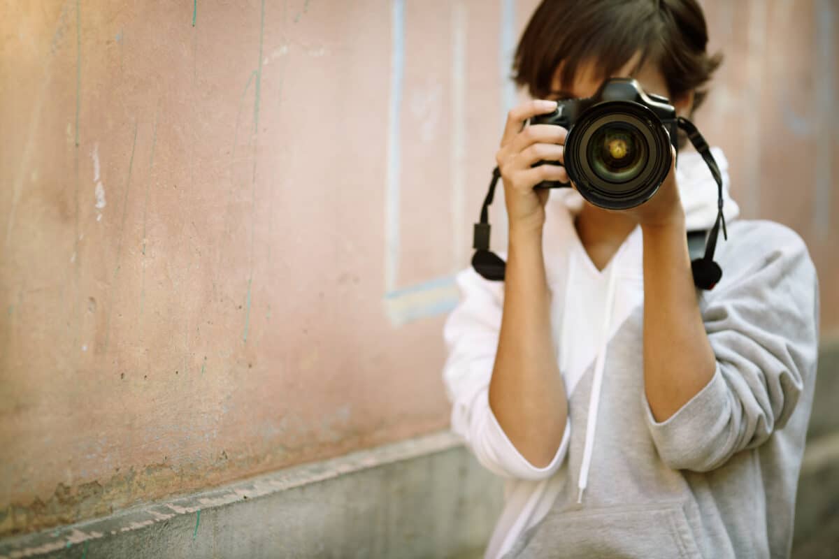female photographer holding professional camera taking a photo
