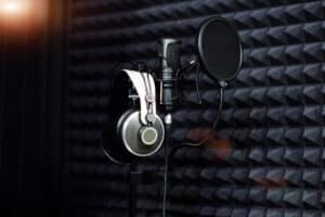 Microphone close - up on the background of a professional recording Studio. Workplace singers and musicians. Microphone stand and headphones for records vocals, speakers and sound of musical instrumen