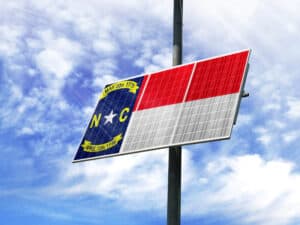 Solar panels against a blue sky with a picture of the flag State of North Carolina