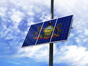 Solar panels against a blue sky with a picture of the flag State of Pennsylvania