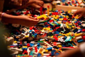 Huge pile of colorful lego bricks with childrens hands