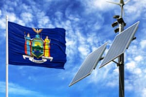 Solar panels on a background of blue sky with a flagpole and the flag State of New York