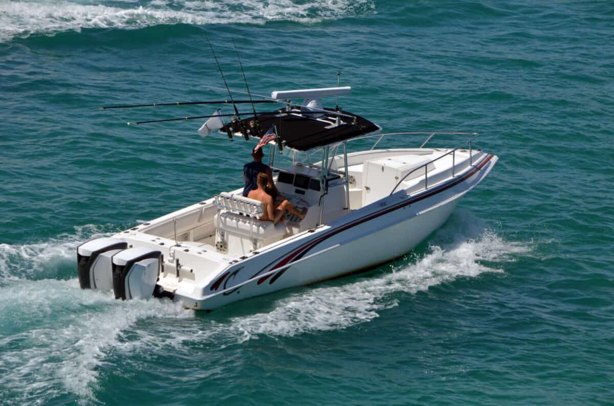 Small open white fishing boat with center console cruising the Florida Intra-Coastal Waterway off Miami Beach.