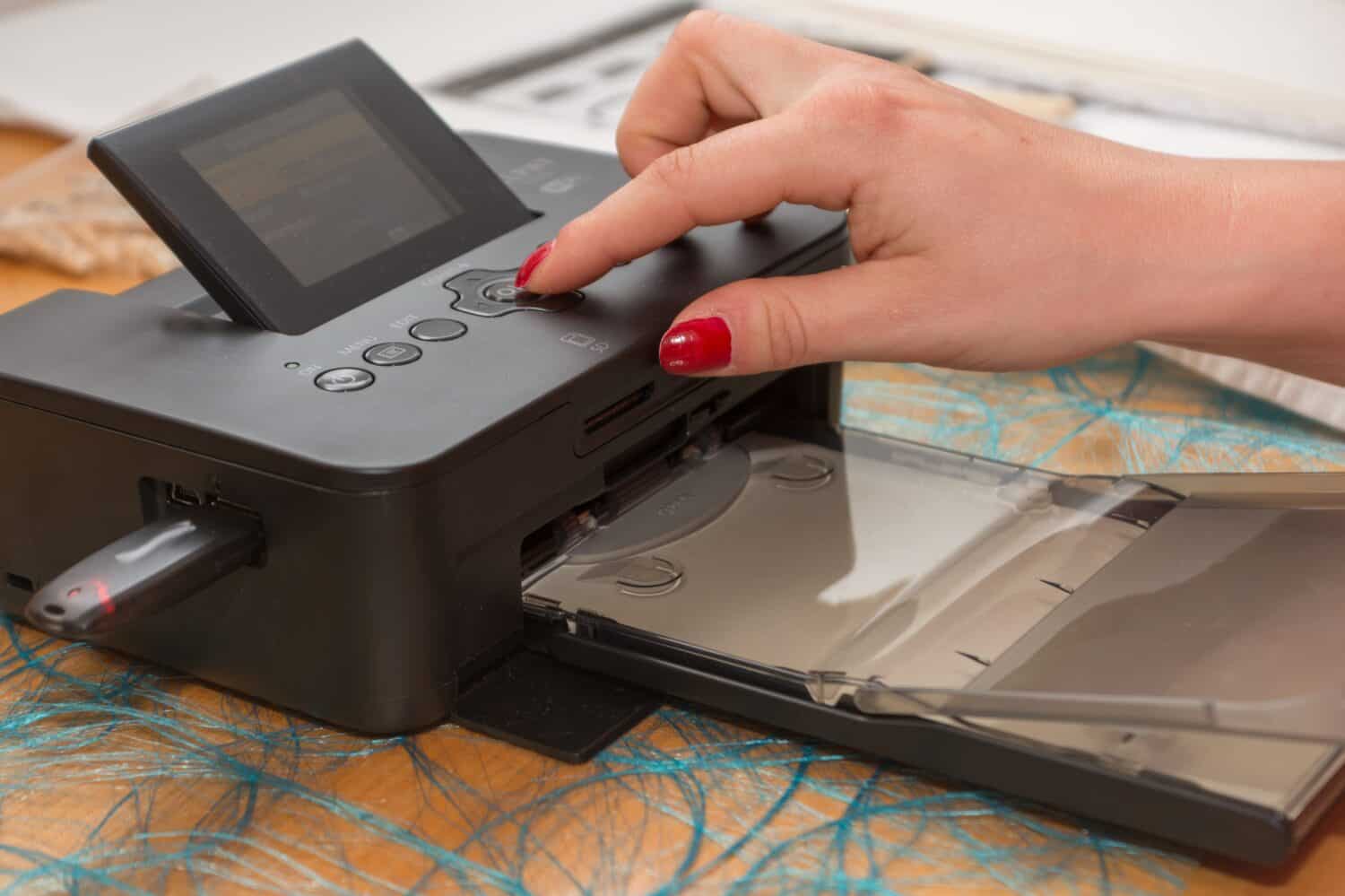 on portable inkjet photo prints - closeup woman hand operated printer