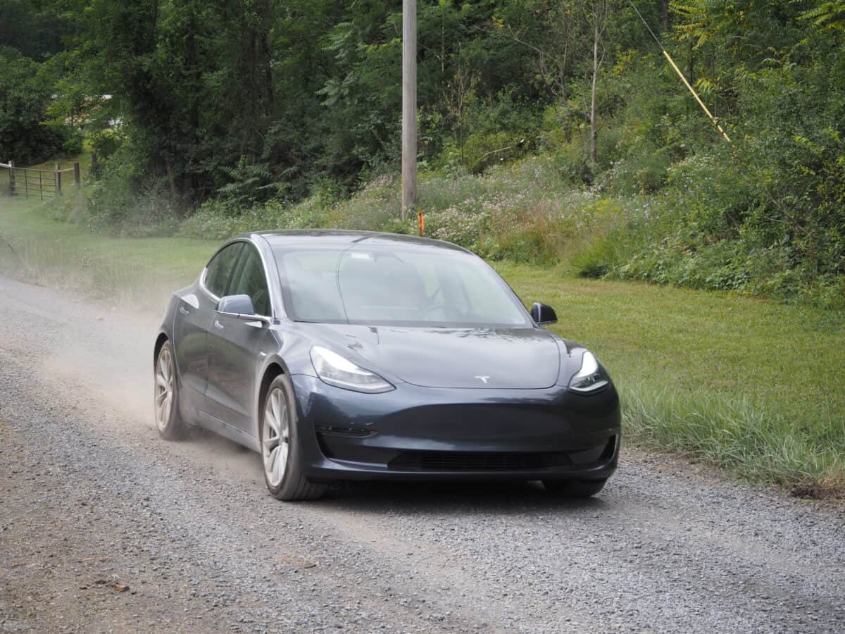 Tesla Model 3 Driving Down Dirt Road