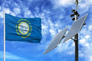 Solar panels on a background of blue sky with a flagpole and the flag State of South Dakota