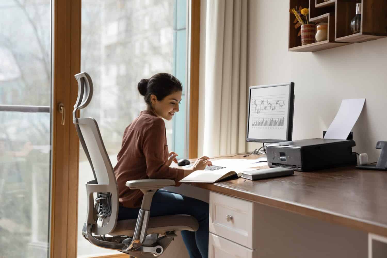 Young woman in a home office using one of the best office chairs recommended by Reddit