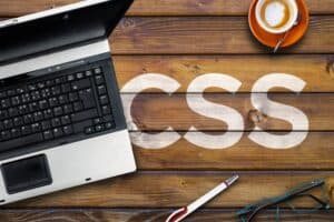 Cascading Style Sheets. Word CSS on wooden desk and laptop