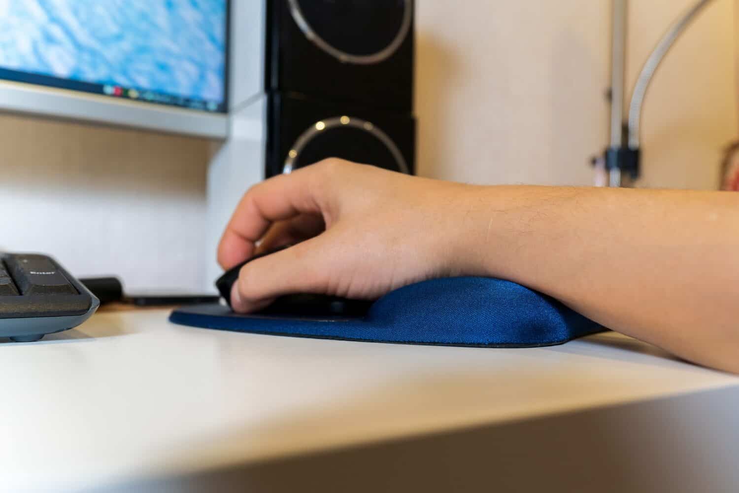 Mouse pads with a gel pad under the wrist. A man hand is working at the computer. Selective focus