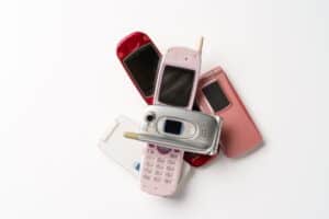 Pile of flip phones on white background