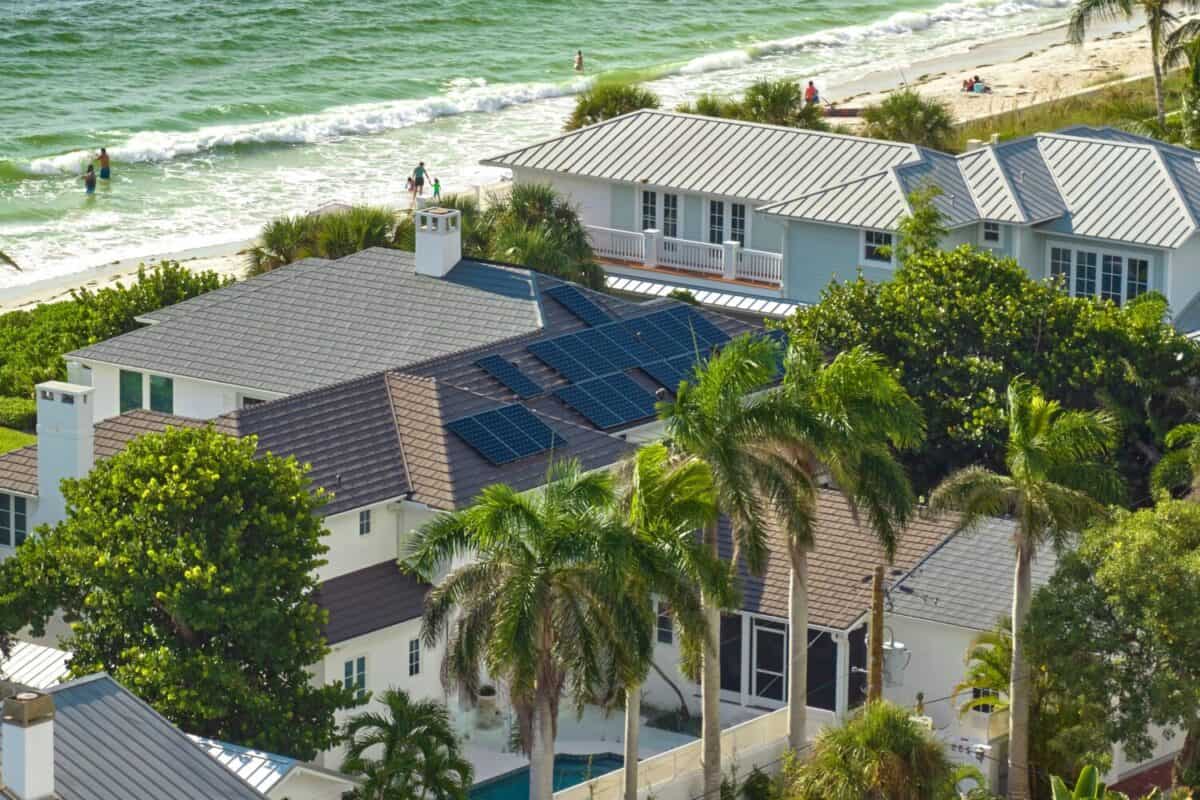 Aerial view of expensive american home roof with blue solar photovoltaic panels for producing clean ecological electric energy. Investing in renewable electricity for retirement income