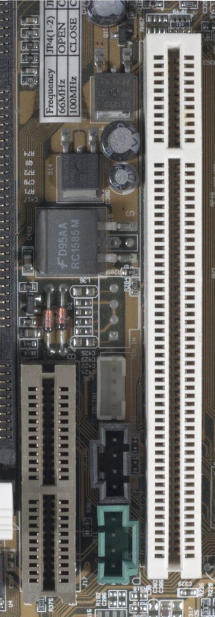 A close up of an audio/modem riser slot on a brown motherboard.