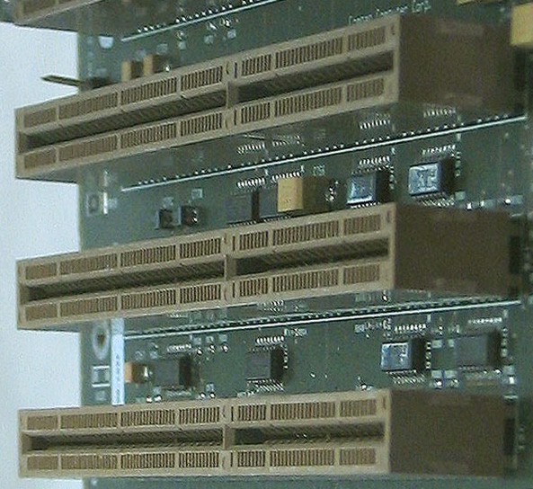 A close up of three Extended Industry Standard Architecture slots on a green motherboard.