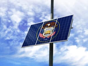 Solar panels against a blue sky with a picture of the flag State of Utah