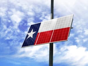Solar panels against a blue sky with a picture of the flag State of Texas