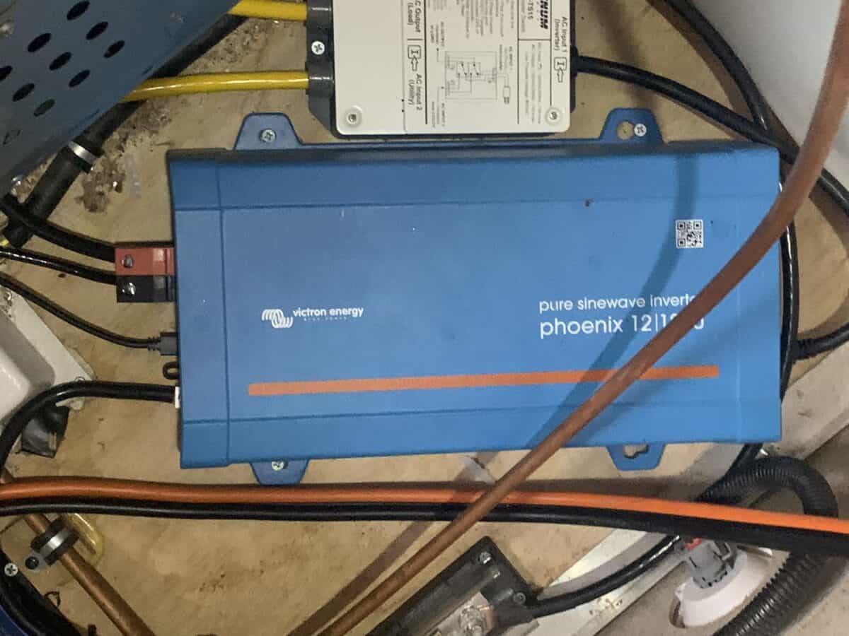 The Victron inverter is mounted underneath a RV stove. The inverter takes stored energy from a bank of batteries and converts it to from 12V to 110V.