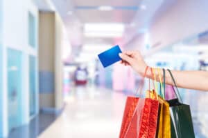 Female hand holding shopping bags and credit card