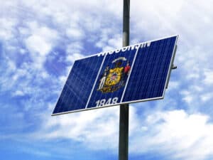 Solar panels against a blue sky with a picture of the flag State of Wisconsin