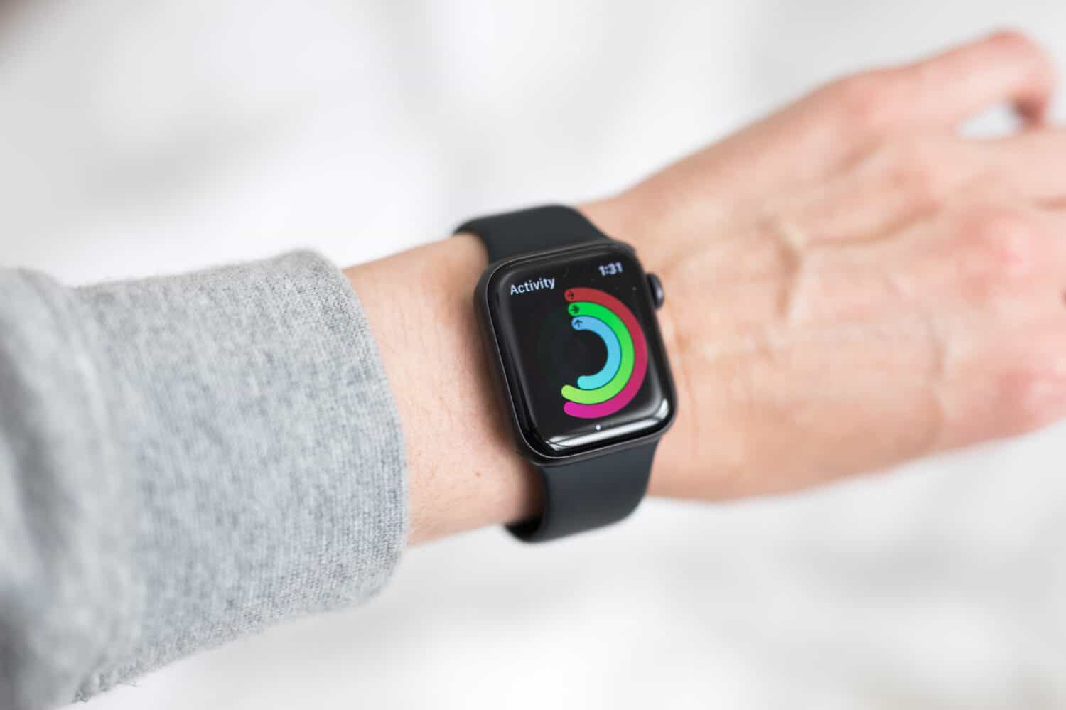 Looking down at woman's hand wrist wearing black apple watch a health fitness watch tracker to monitor heart rate, activity levels, execise fitness movement. Keeps you fit and motivated. Modern