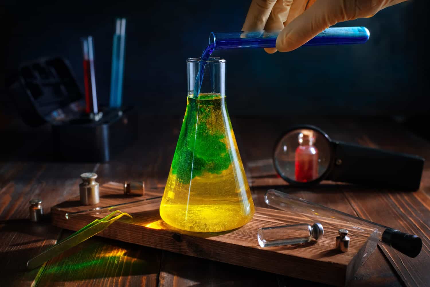 scientist pours blue liquid into yellow in a chemical flask. color change. science, experiments