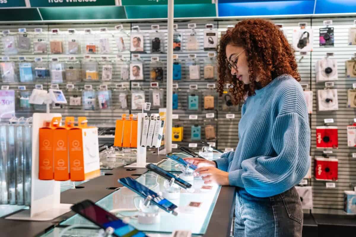 African American woman touching phone screen in shop